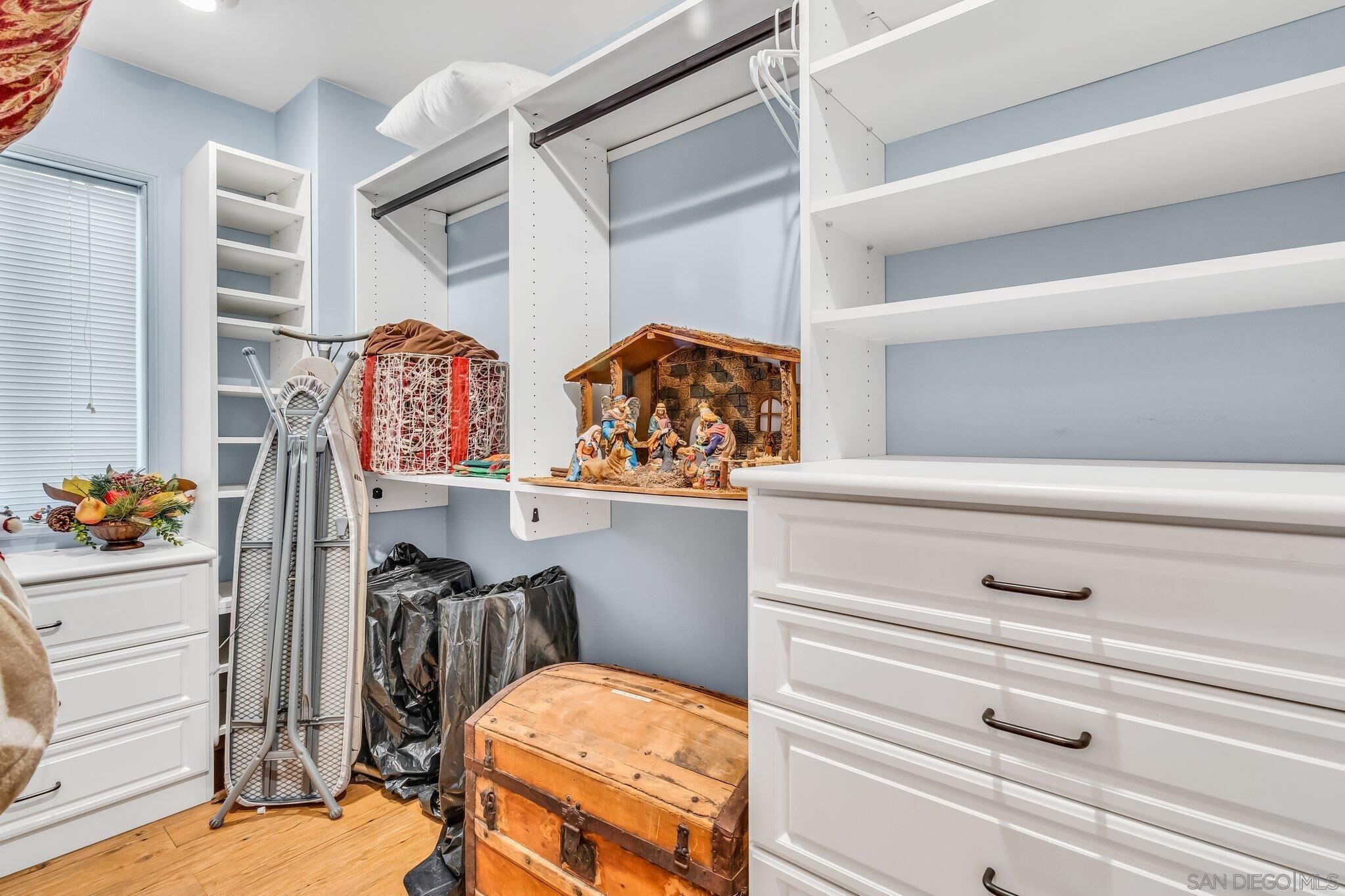 A compact room with white cabinetry, a small wooden chest, and a decorative nativity scene.