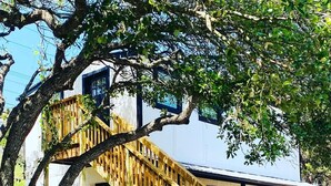 A two-story building with a wooden staircase leading to the upper floor. - Casita in the Oaks (Canyon Lake)