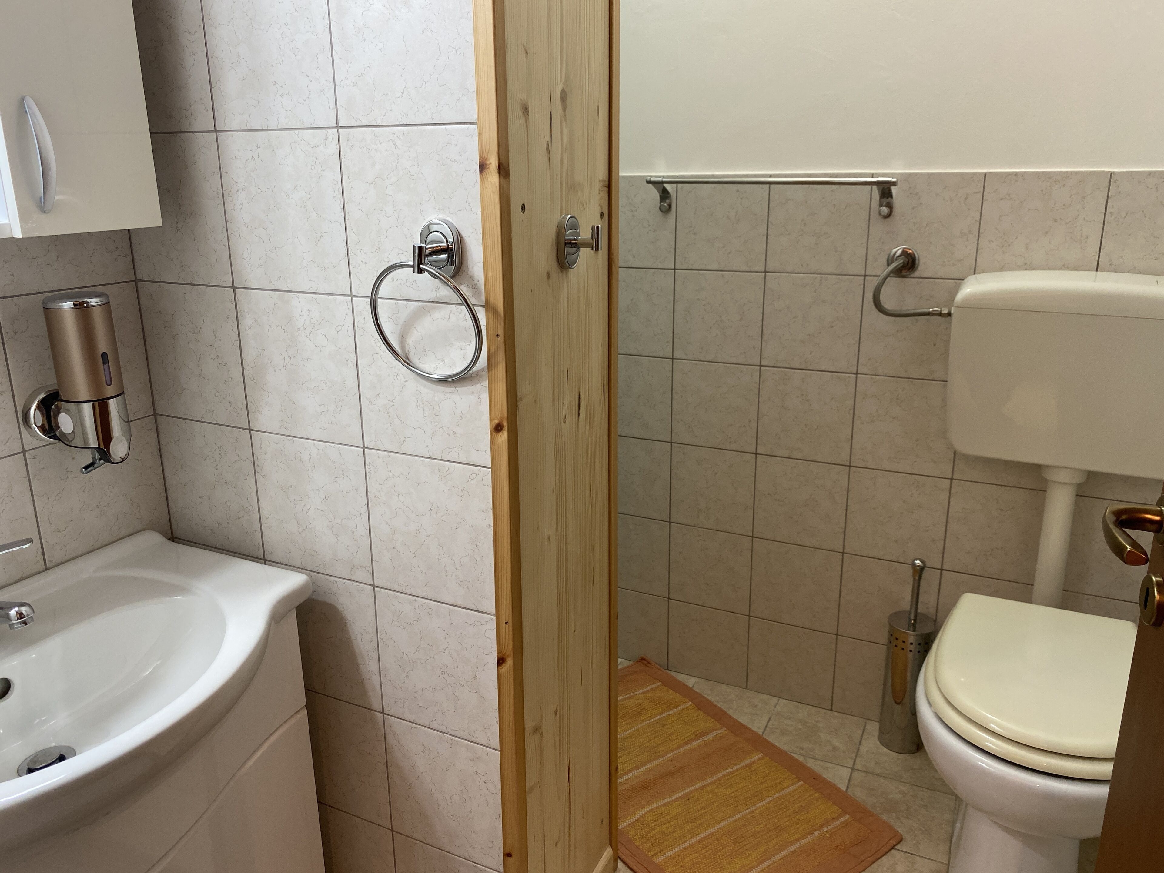 A bathroom with a sink, toilet, and shower area.