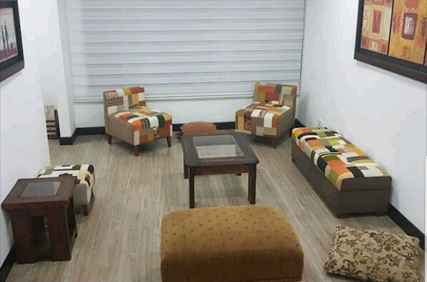 Cozy living space with a central table, two sofas, and two armchairs.