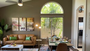 A modern living room with a dining area, large windows, and a ceiling fan. - Luxury Lakeside Home! Private Pool, Dock, Outdoor Kitchen, & Private Courtyard! (Glendale)