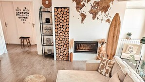 Una sala de estar acogedora con una mesa de centro de madera, un sofá color beige, una chimenea y un mapa mundial en la pared.