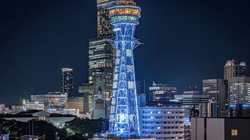 A high-rise building with a prominent tower structure, surrounded by other buildings in a cityscape.