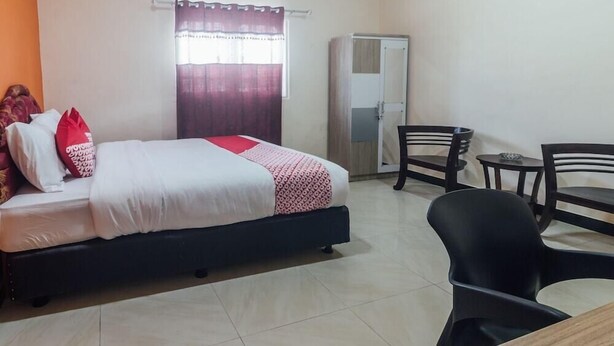 A bedroom with a bed, a desk, and a chair. - OYO 2010 Satria Guest House (Ambon)