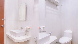 Une salle de bain avec deux lavabos, des toilettes et un miroir.
