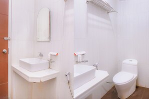Ein Badezimmer mit zwei Waschbecken, einer Toilette und einem Spiegel.