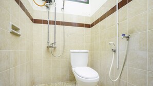A bathroom with a toilet, shower, and tiled walls. - Oyo 2004 Penginapan Bidara Syariah (Probolinggo)