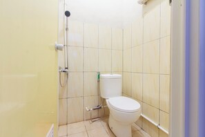 A small bathroom with a toilet, a shower, and a sink.