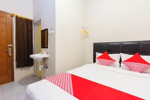 Une chambre d’hôtel avec un lit, une salle de bain et une porte.
