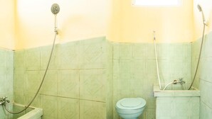 Une petite salle de bain avec des toilettes, une douche et une baignoire.