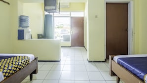 Une chambre d’hôtel avec deux lits, une télévision, un distributeur d’eau et une vue sur l’extérieur.