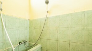 Casa de banho com chuveiro, banheira e sanita.