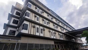 A multi-story building with a modern architectural design, featuring balconies and large windows.