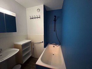 Ein Badezimmer mit Badewanne, Waschbecken und Handtuchhalter.