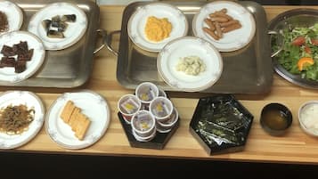 Diversos pratos em uma bandeja, incluindo macarrão, carne e legumes.