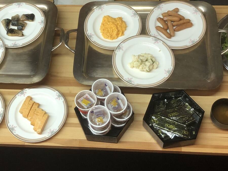 Diversos pratos em uma bandeja, incluindo macarrão, carne e legumes.