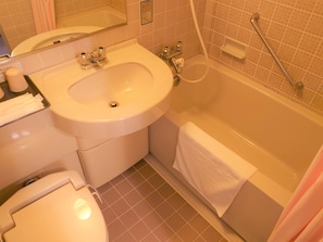 Bathroom features a sink, toilet, and bathtub with handheld showerhead and grab bar.