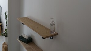 A corner with a wooden shelf, a black metal hanger, and a small bottle on the shelf. - Spacious and Cosy Studio - Strasbourg Centre (Strasbourg)