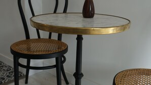 A round table with a gold rim and a dark vase with dried flowers. - Spacious and Cosy Studio - Strasbourg Centre (Strasbourg)