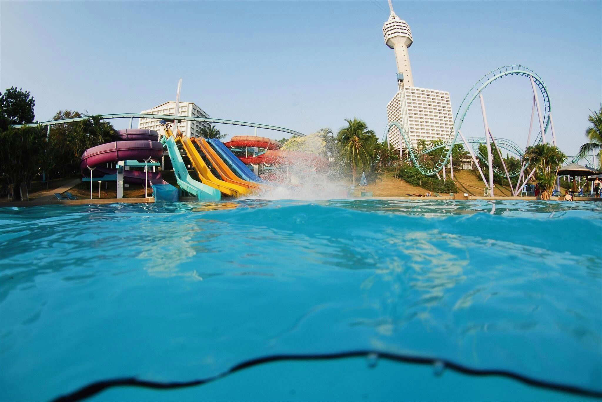 A water park with a pool, water slides, and a tower structure.