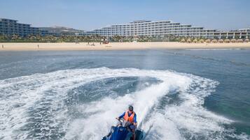 Un jet ski sobre el agua, con un hotel al fondo.