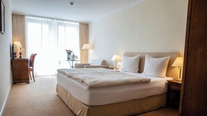 A hotel room with a large bed, bedside tables, a desk, and a chair. - Altstadthotel Weinhaus Messerschmitt (Bamberg)