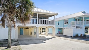 A beachfront property with a covered patio, a two-story building, and a separate structure with a balcony. - Beach house with ground floor mother in law suite! (Port St Joe)