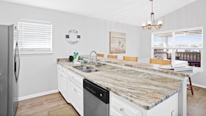 A modern kitchen with a marble countertop, stainless steel sink, and a dishwasher. - Beach house with ground floor mother in law suite! (Port St Joe)