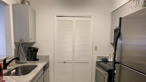 A compact kitchen with a built-in oven, a stainless steel refrigerator, and a double sink. - St Simons Island,  2 bedroom, 2 bath condo, short walk to village and beaches. (St. Simons)