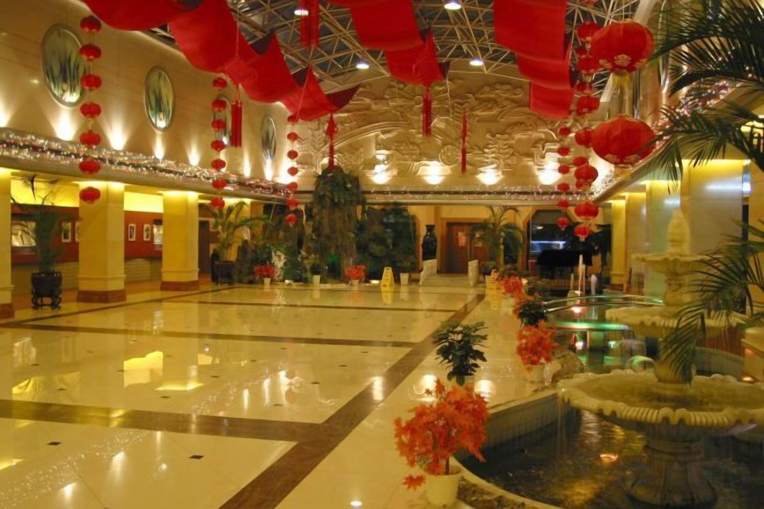 A spacious lobby with a fountain, red lanterns, and a large mirror.