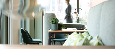 Ein modernes Zimmer mit Schreibtisch, Stuhl und großem Fenster.