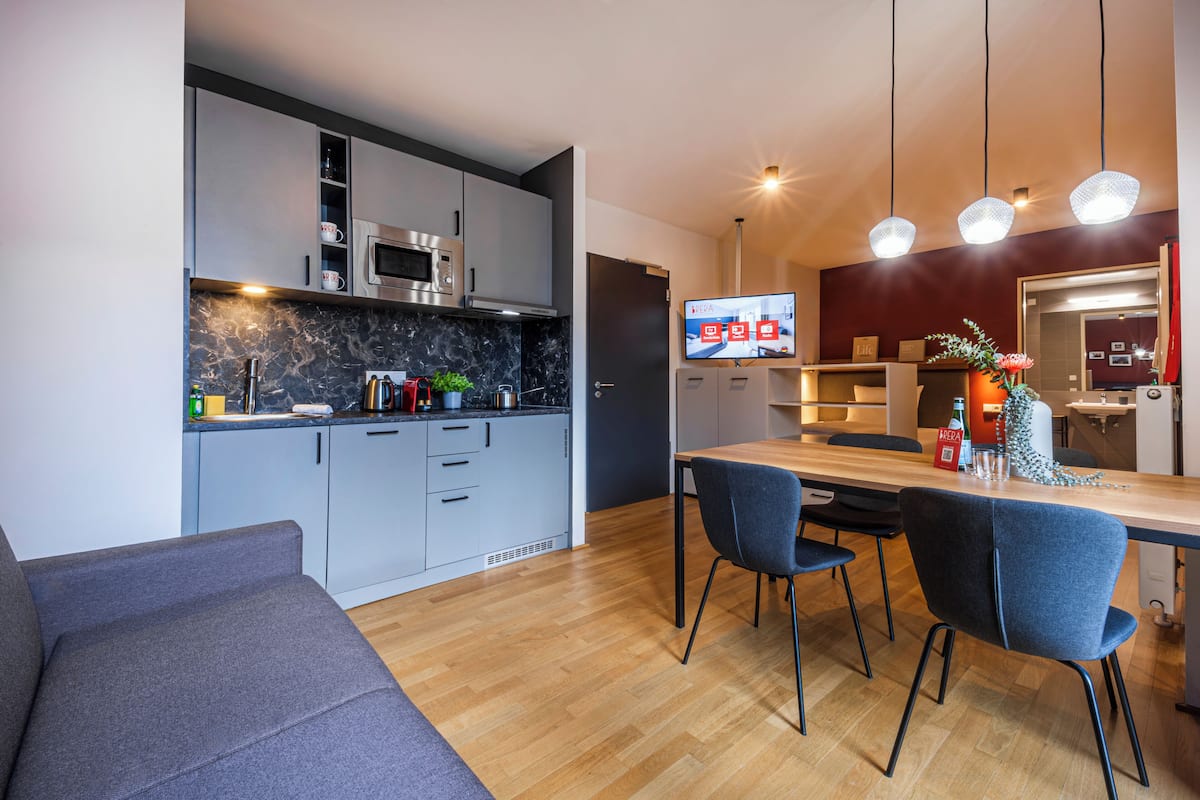 Una cocina moderna con armarios grises, una mesa de comedor de madera y sillas azules.