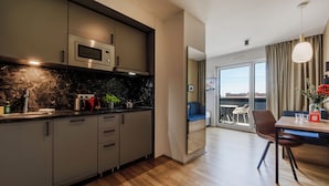 Uma cozinha moderna com micro-ondas embutido, pia e área de refeições com mesa e cadeiras.