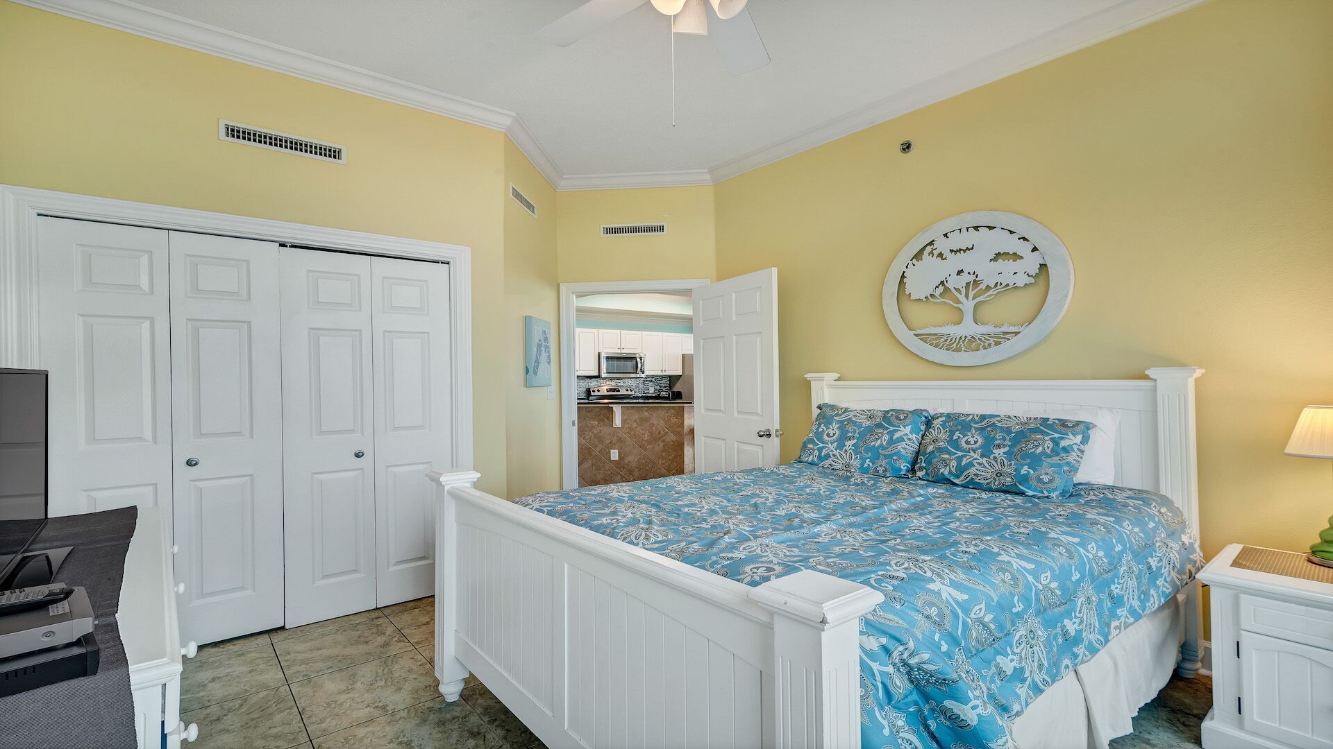 A bedroom with a bed, a desk, and a chair. There is a door and a window.