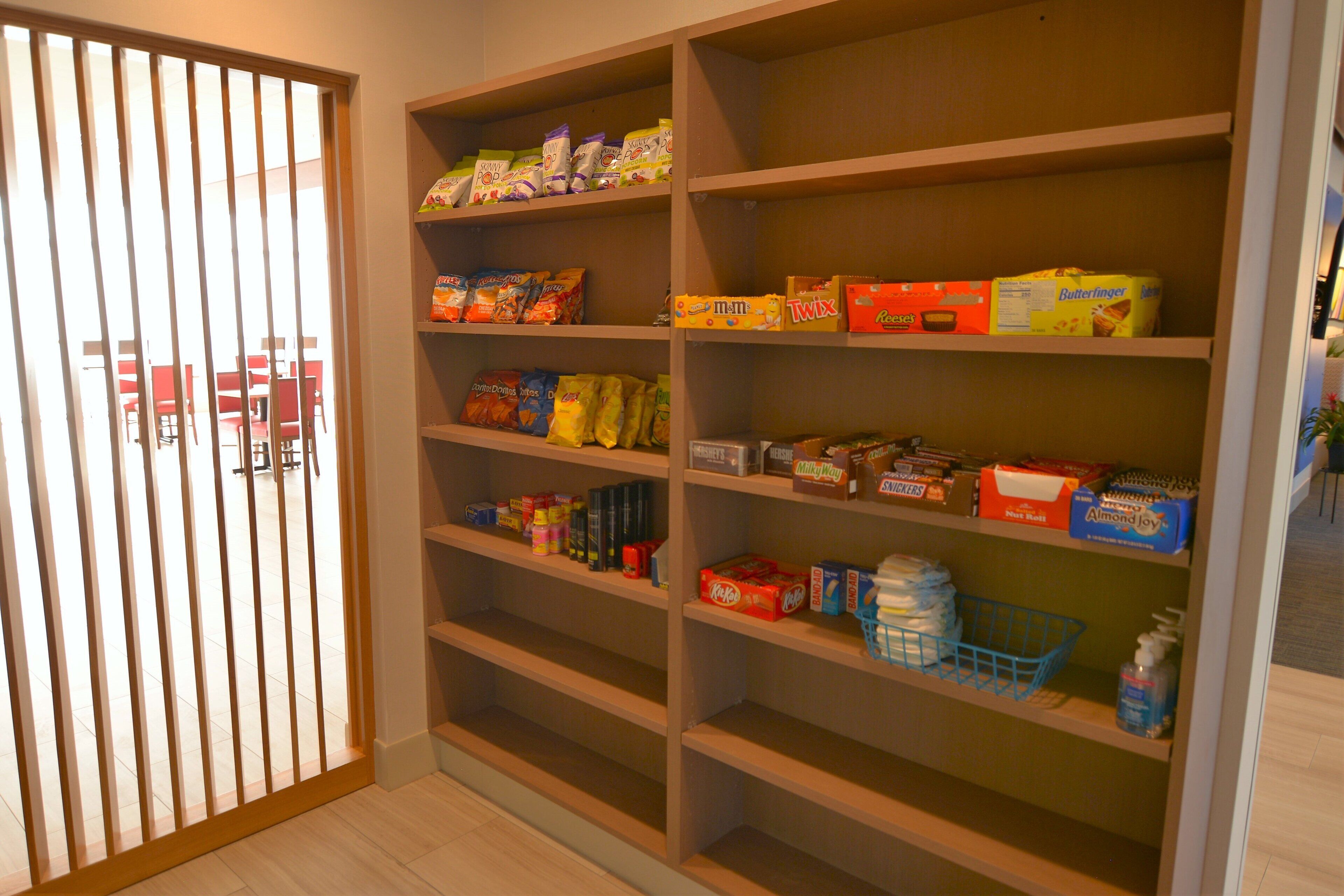 A pantry with shelves stocked with various food items and household supplies.