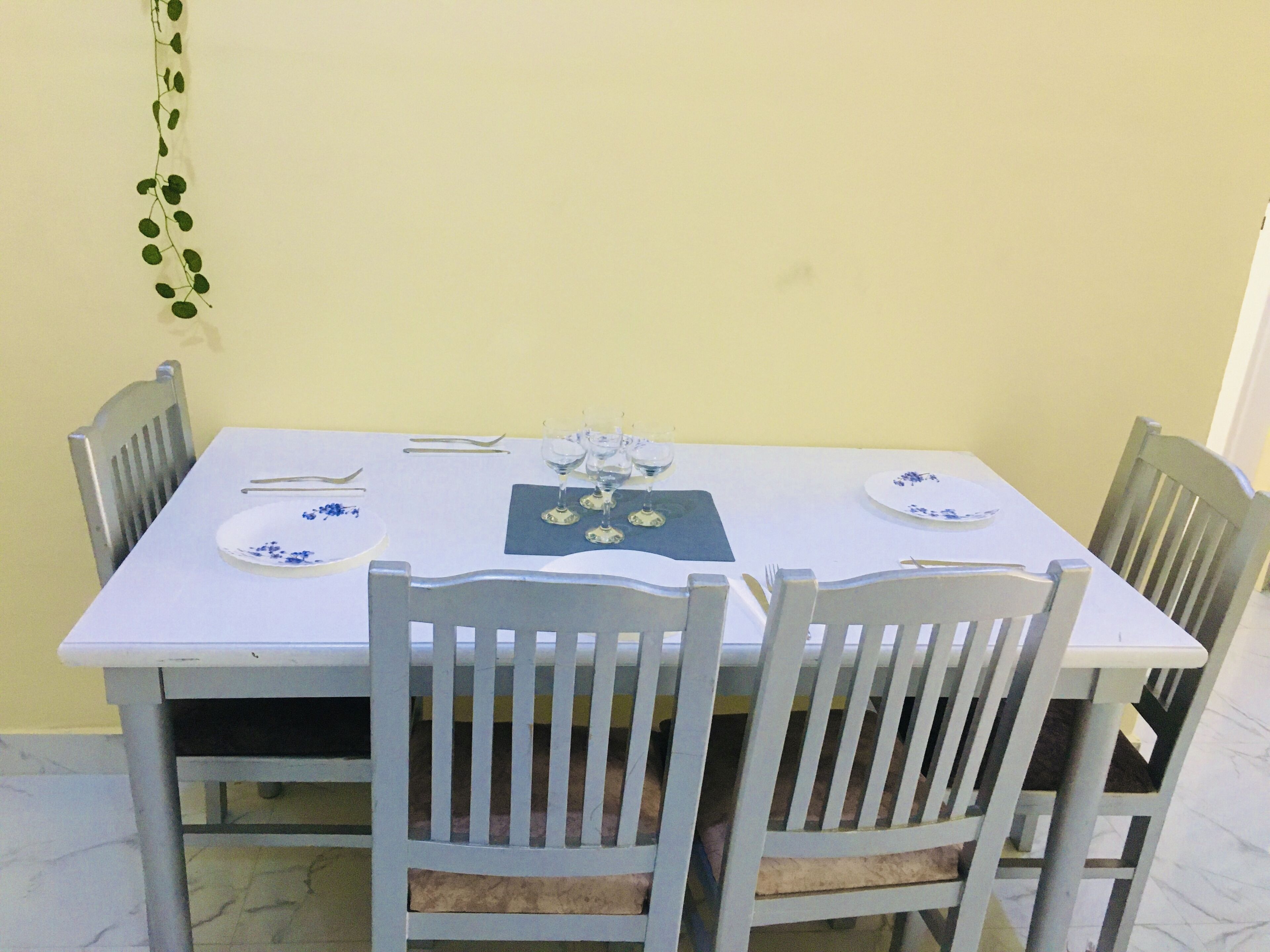 A dining table set with plates, cutlery, and wine glasses.