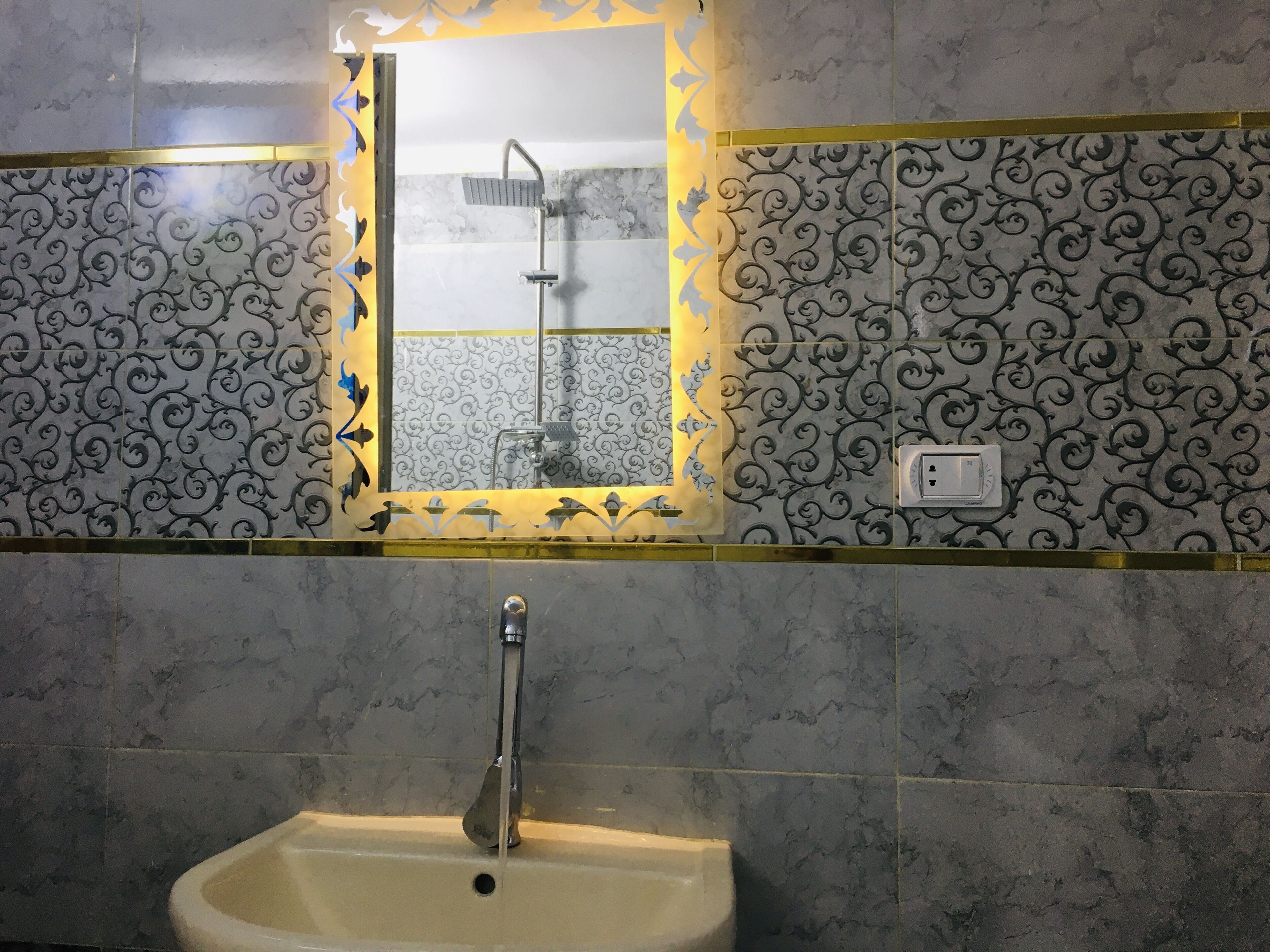 A bathroom with a sink, a mirror, and a shower.