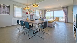 Un espace de vie moderne comprenant un coin repas, un canapé, un téléviseur et un balcon avec vue.