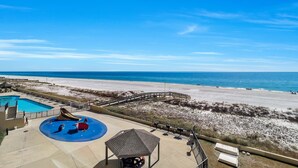 A beach view with a pool, a slide, and a gazebo.