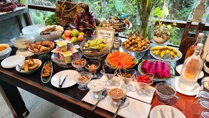 A buffet table with various food items and condiments.