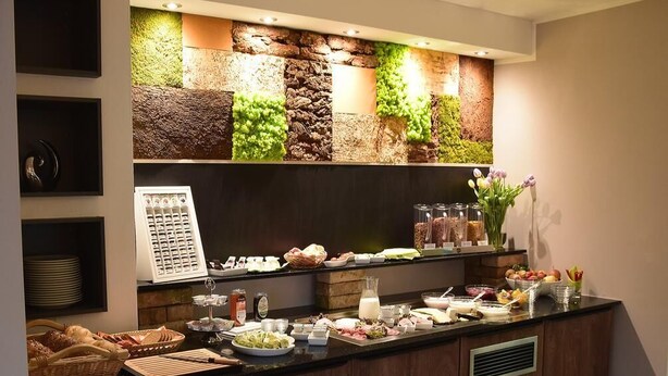 A buffet setup with various food items and a menu board.