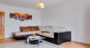 Relax in a stylish living room with a light-colored sofa, coffee table, and pendant light.