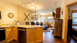 A spacious kitchen with wooden cabinets, a granite countertop, and a built-in dishwasher. - River Run Condo w/ Courtyard Views on Private Balcony, Close to Gondola/Shops (Keystone)