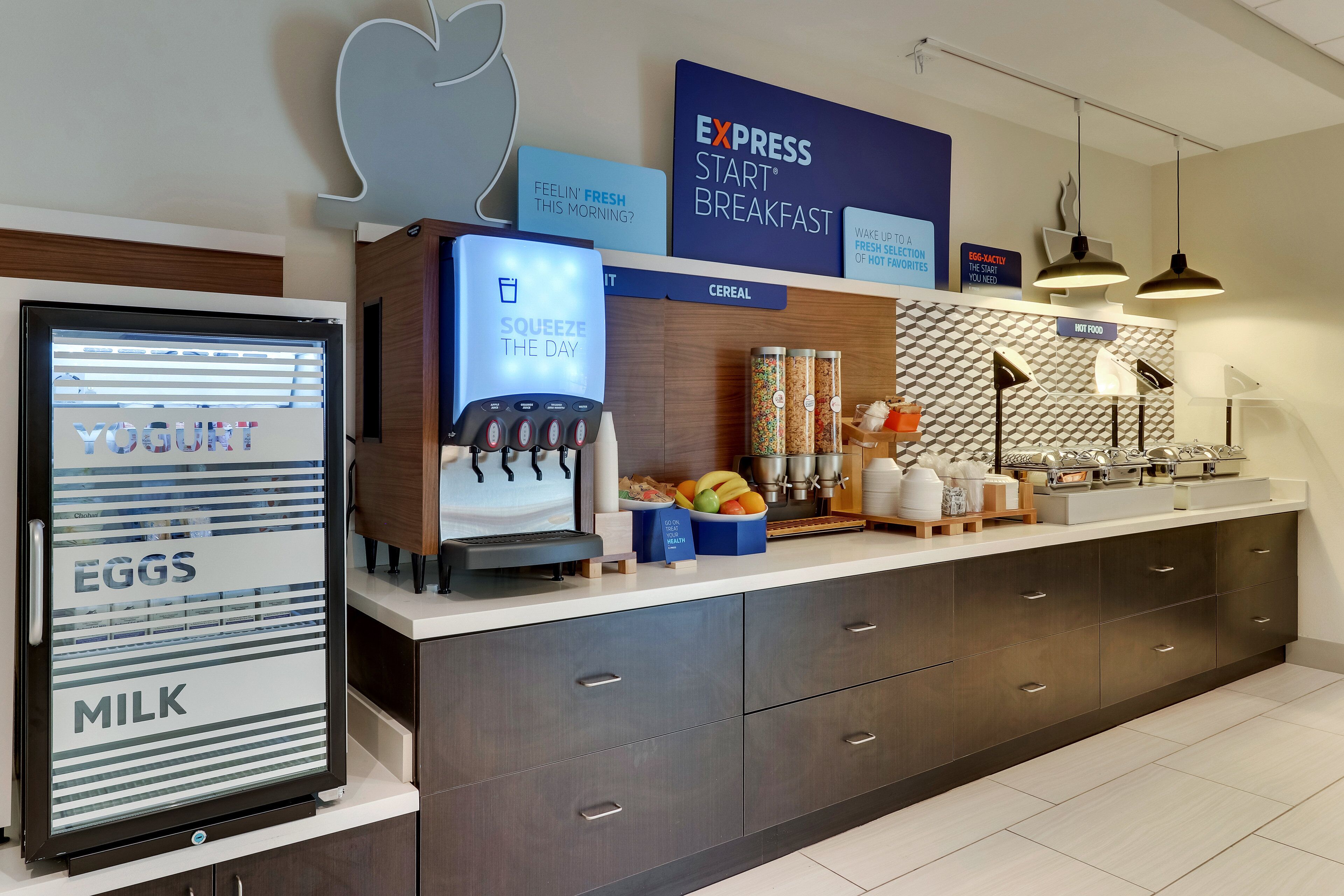 A breakfast station with a yogurt dispenser, a coffee machine, and a cereal display.