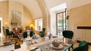 A dining area with a table set for two, a fireplace, and a view of the outdoors. - Palazzo Maresgallo (Lecce)