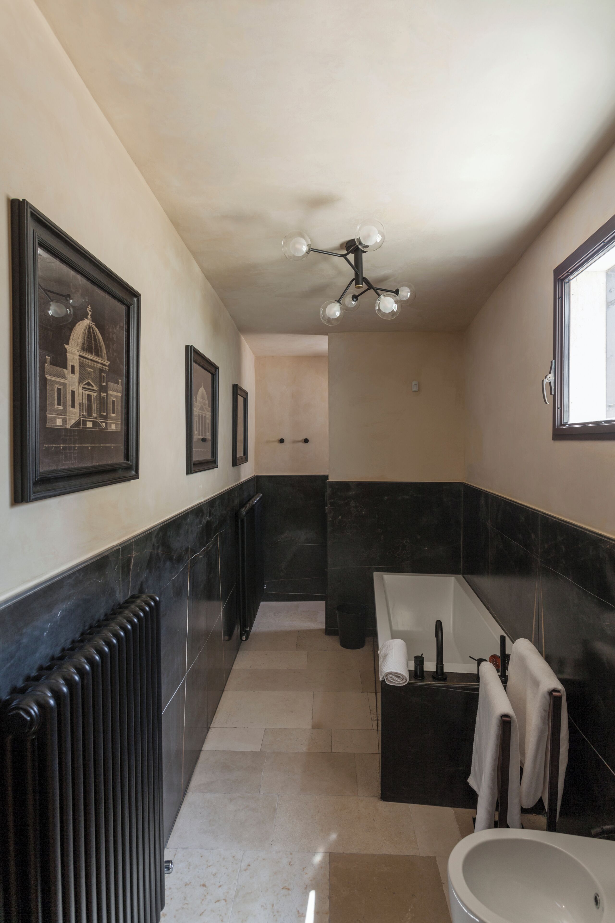 Un baño moderno con un espejo grande, una bañera y un inodoro.