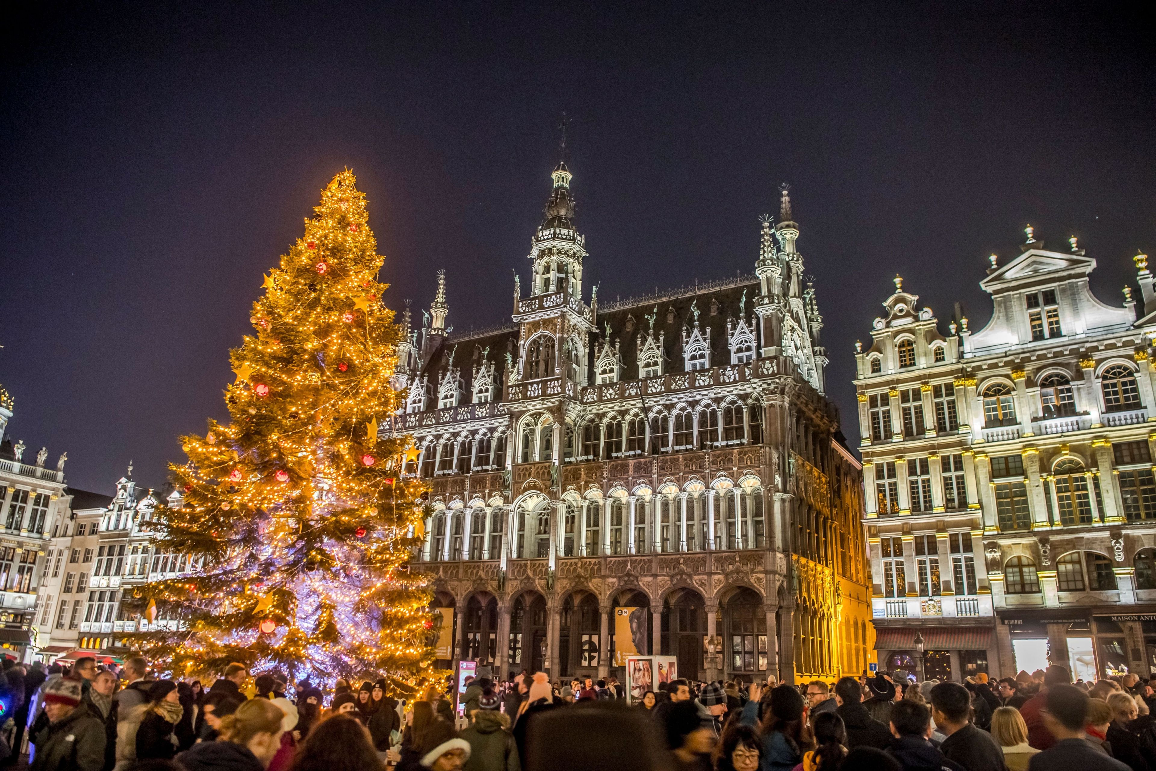A large, ornate building with multiple towers and a crowd of people gathered in front.