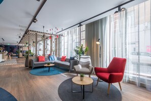 A modern interior with a sofa, armchairs, and a coffee table. - Holiday Inn Express Brussels - Grand-Place by IHG (Brussels)
