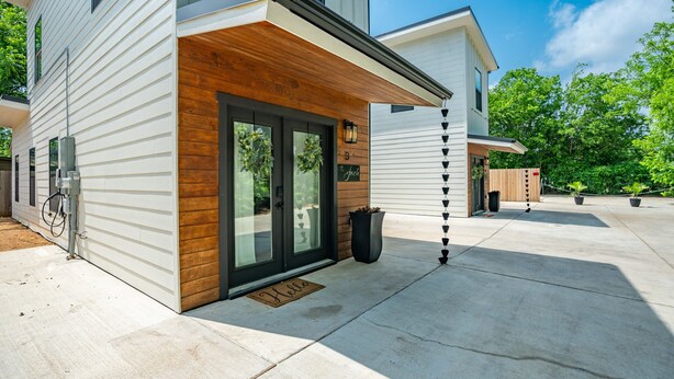 A modern house with a wooden front porch, a garage door, and a mailbox. -  THE JACK 3 (Waco)