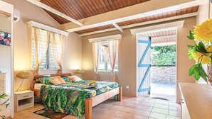 Un dormitorio con cama, cortinas, una ventana y vistas al exterior.